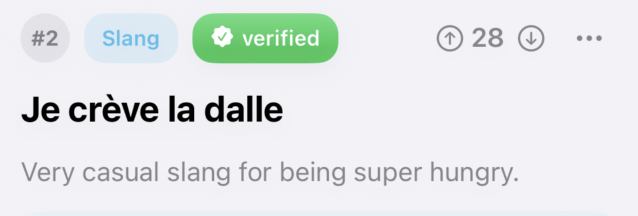 A community translation ranked #2 and tagged Slang, carrying a green verified badge and 28 upvotes: “Je crève la dalle” — very casual slang for being super hungry.